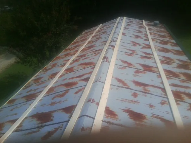 Rusted metal roof panels with new wood purlins before replacement — Storm Damage Roof Repair in Robards by Roofing Brothers